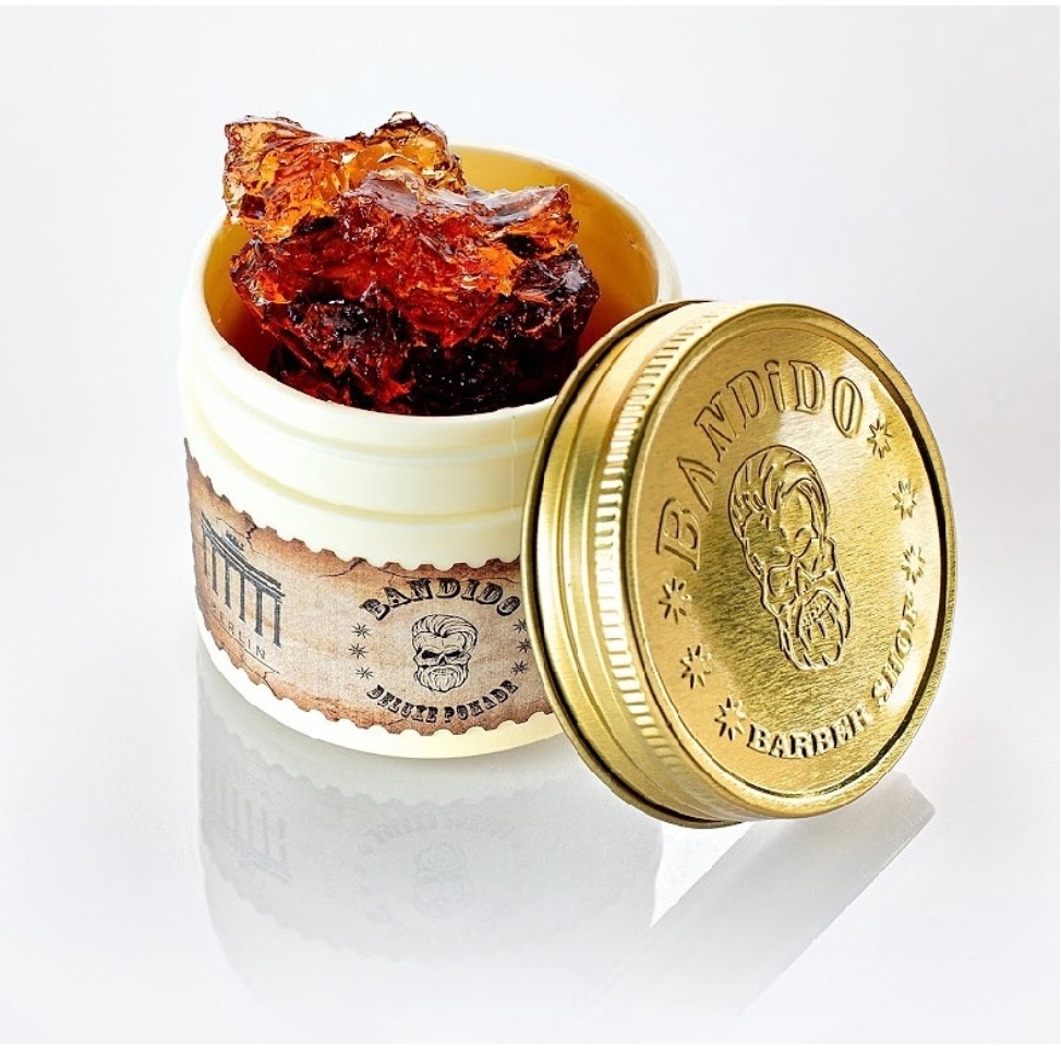 Recipiente branco com tampa dourada e gel castanho-avermelhado