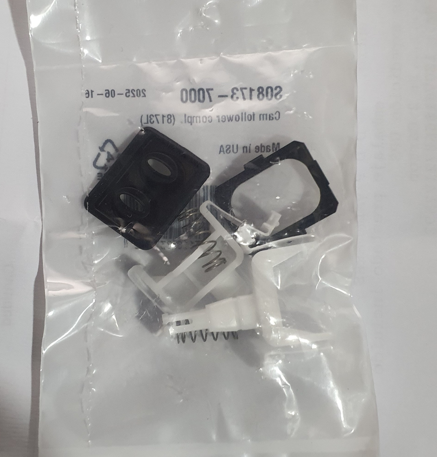 Peças plásticas e metálicas em saco plástico transparente com texto impresso azul