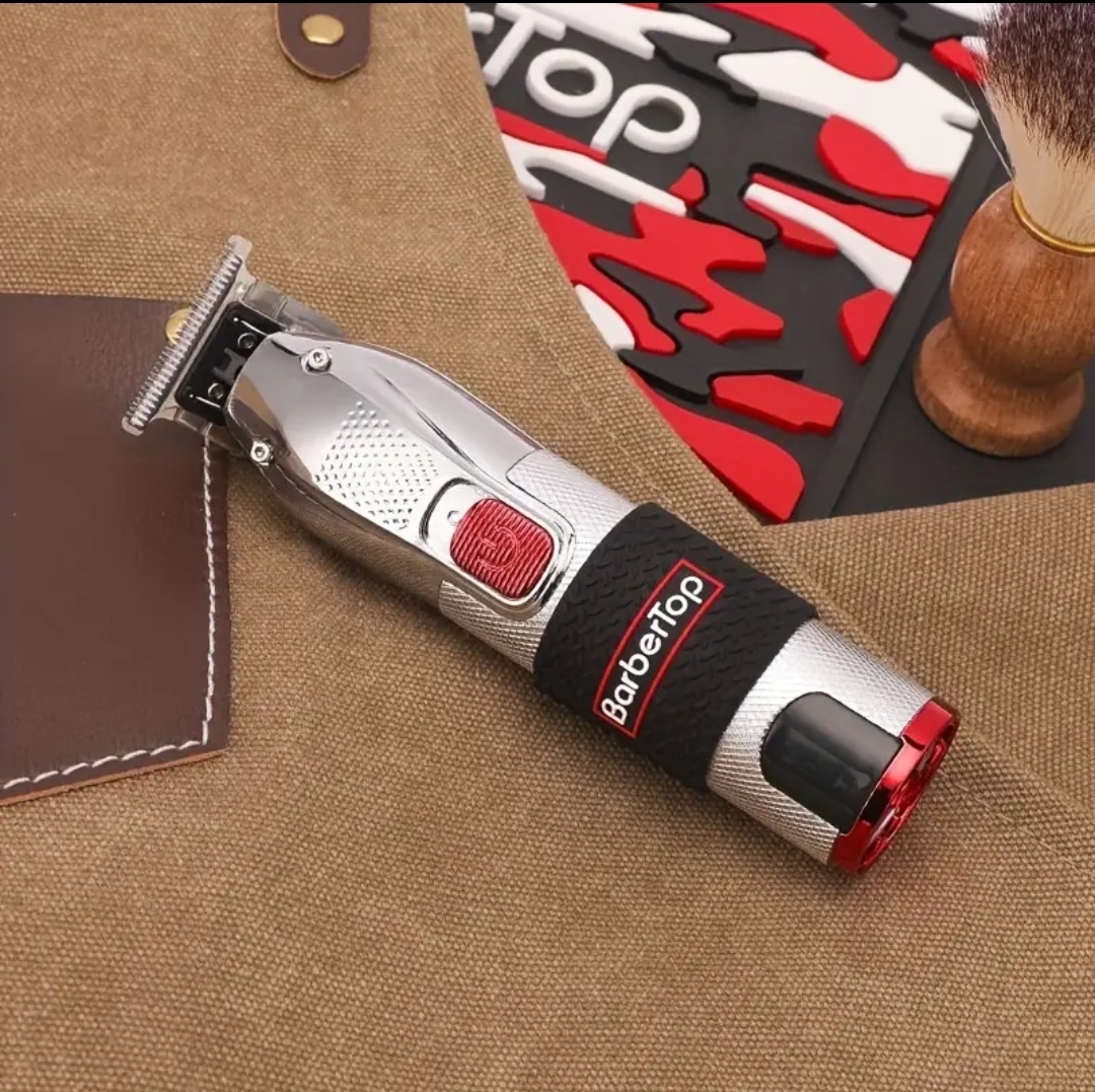 Aparelho de barbear elétrico BareTop prateado com detalhes vermelhos e etiqueta preta sobre tecido bege