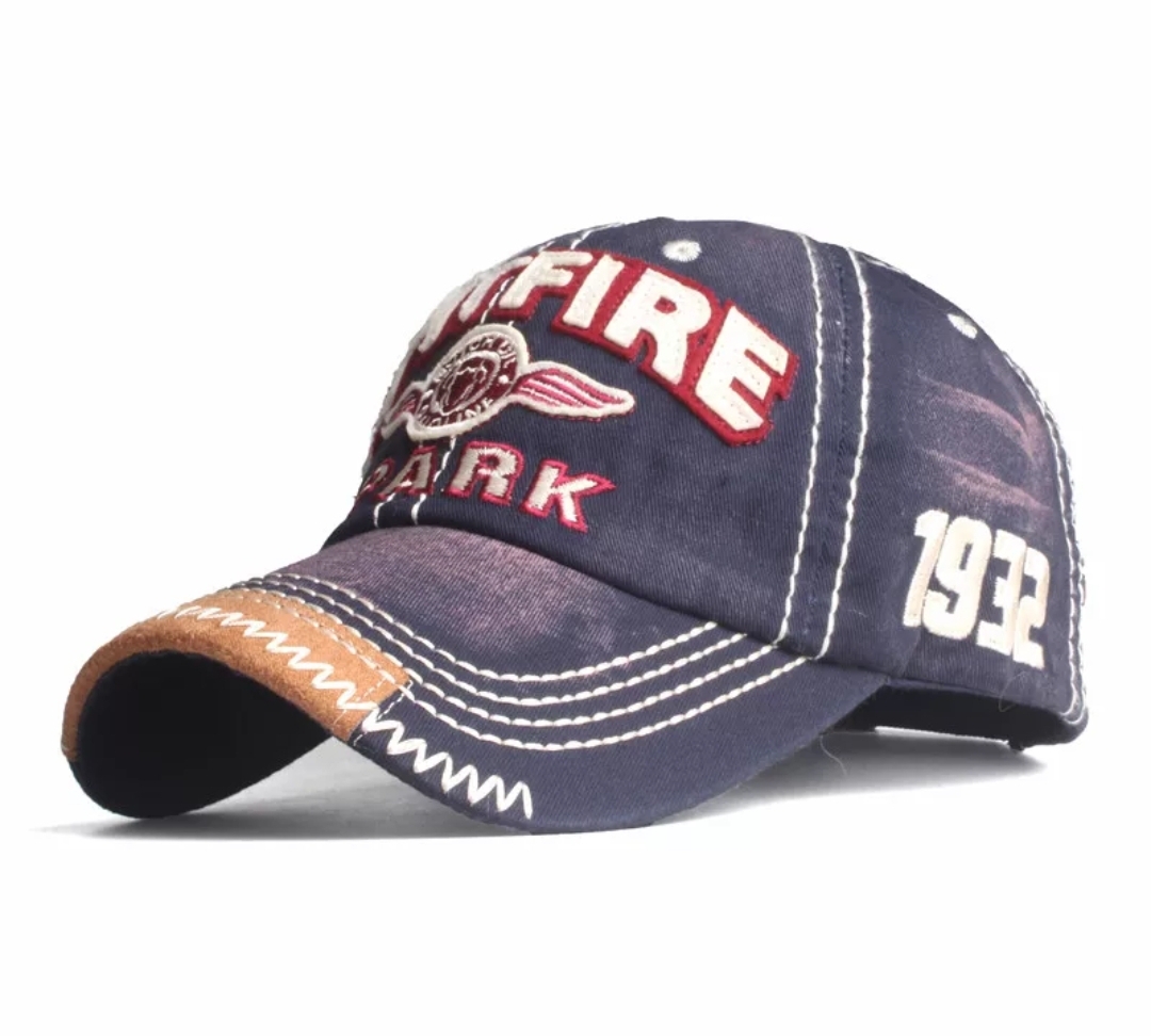 Boné azul escuro com bordados vermelhos, brancos e castanhos, com aba curvada e número 1932 bordado.