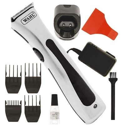 Máquina de cortar cabelo WAHL com acessórios, incluindo pentes, escova, óleo, carregador e base.