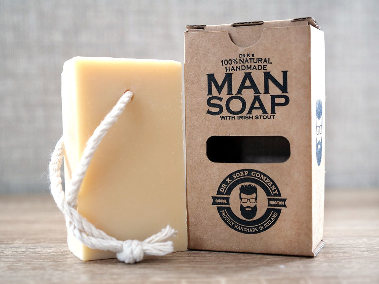 Sabonete amarelo com cordão e embalagem de papel kraft com texto preto