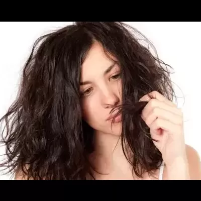 Mulher com cabelo escuro, longo e ondulado, roupa branca