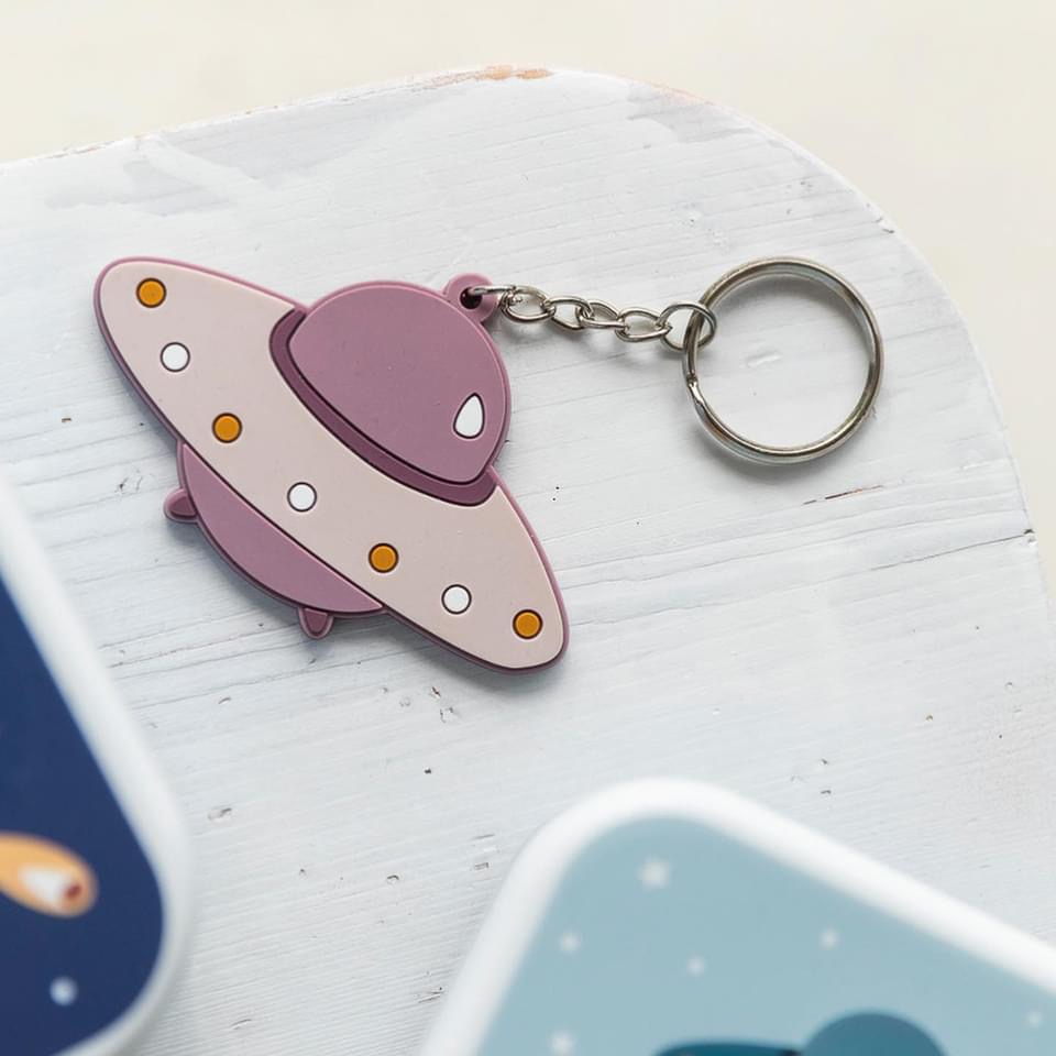 porta-chaves nave espacial lilás em superfície branca