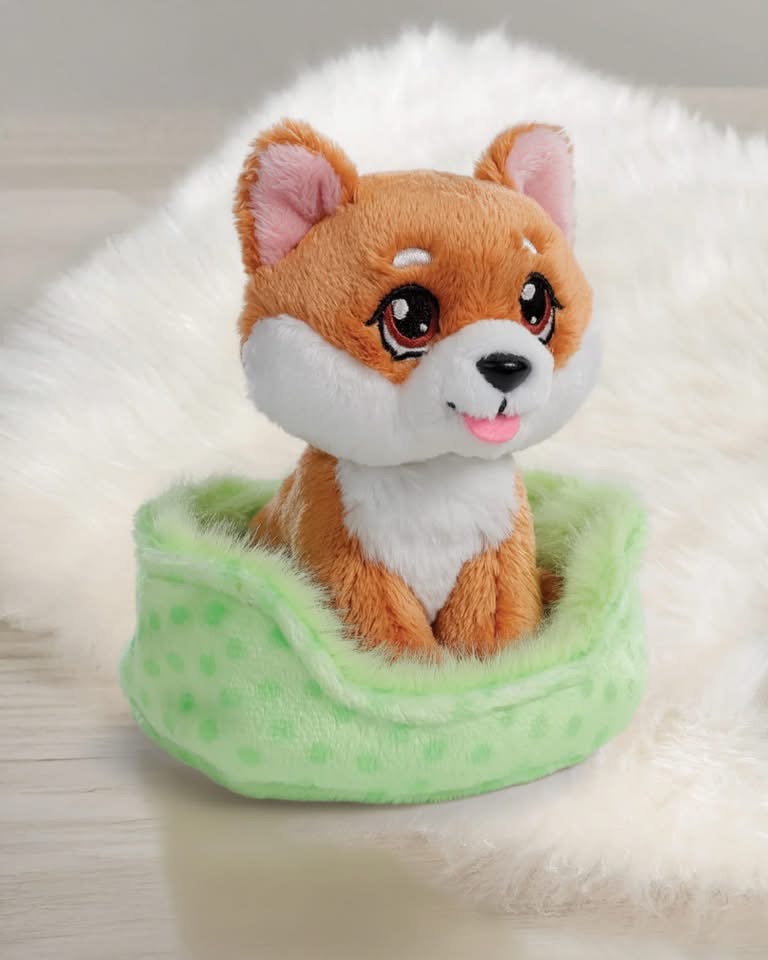 Pelúcia de cão castanho claro e branco numa cama verde com bolinhas