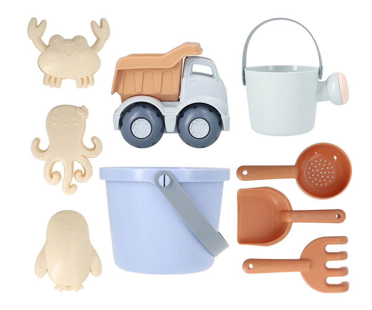Brinquedos de praia coloridos incluindo balde, regador, camião basculante e figuras de animais.