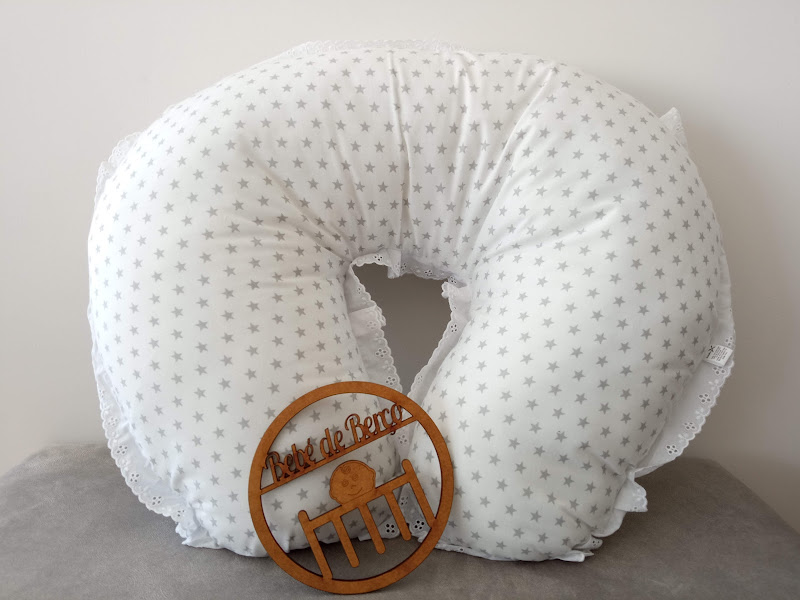 Almofada branca em forma de U com estrelas cinzentas e ornamento de madeira com texto