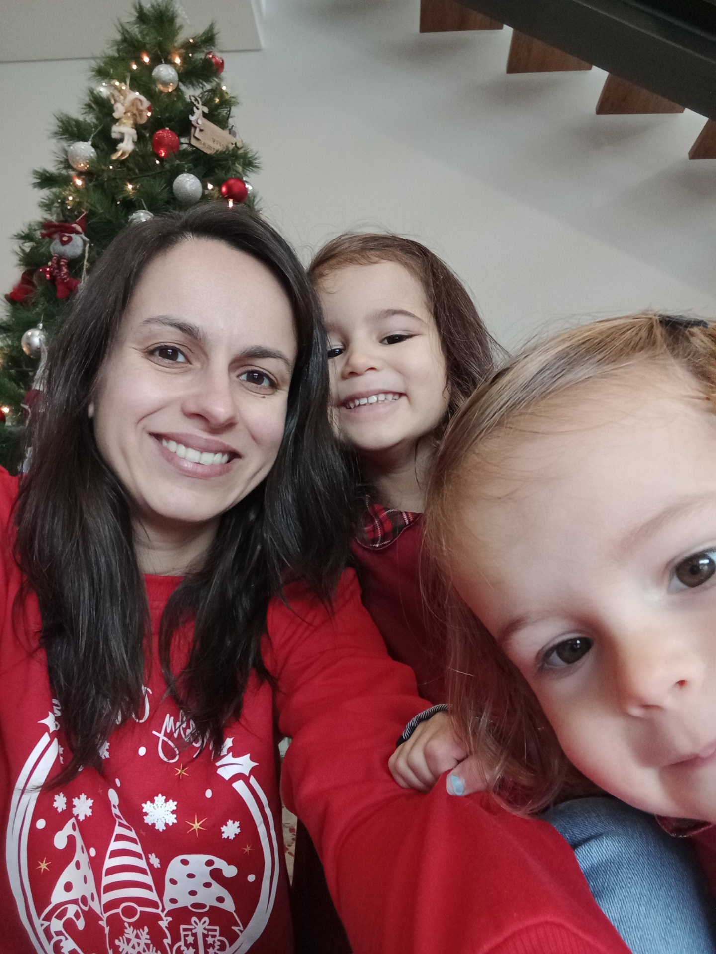 Boas Festas a todos ❤️ Mulher e crianças com roupa vermelha em frente a árvore de Natal decorada