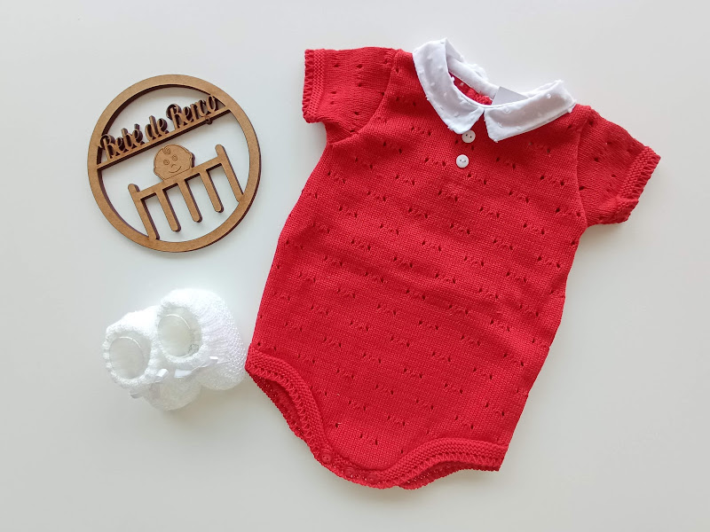Body de bebé vermelho com gola branca e sapatinhos brancos em fundo branco