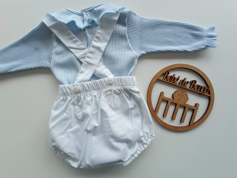 Conjunto de roupa de bebé azul clara com calções brancos e placa decorativa em madeira