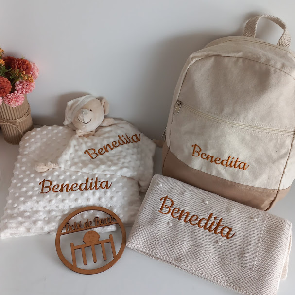 Conjunto de mochila, manta, toalha personalizados com o nome Benedita em tons bege e branco, com um peluche de ovelha e decoração redonda em madeira