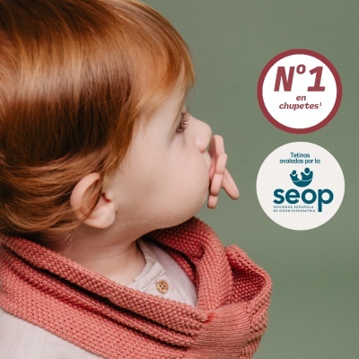 Criança com chupa cor de pele e gola de malha rosa