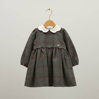 Vestido infantil cinza com xadrez vermelho, gola branca e mangas compridas pendurado num cabide.
