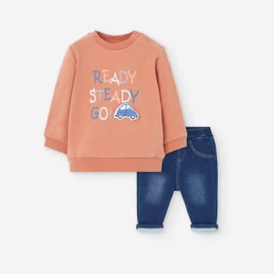 Conjunto infantil com camisola coral estampada e calças de ganga azul.