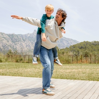 Homem e menino a brincar ao ar livre com montanhas ao fundo
