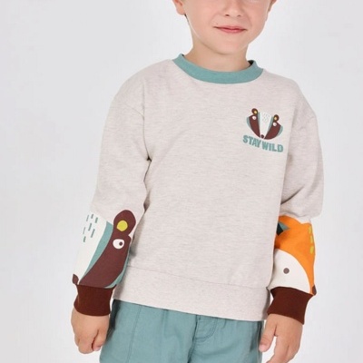 Camisola infantil bege claro com estampas de animais e texto STAY WILD, calças azul-claras