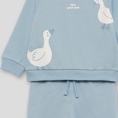 Conjunto de roupa de bebé azul com estampa de patos e texto