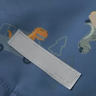 Tecido azul com estampado de dinossauros e etiqueta name it