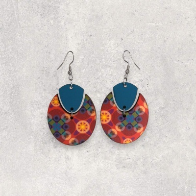 Brincos coloridos com padrão geométrico em fundo cinzento