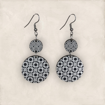 Brincos pendentes pretos e brancos com padrão geométrico redondo