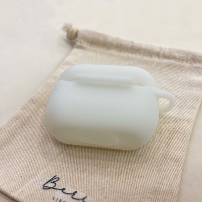 Capa branca para auriculares sobre saco de tecido bege com cordões