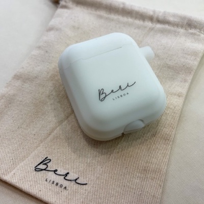 Estojo branco para auriculares sobre saco de pano bege com texto Bee LIZORA