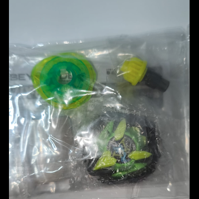 Plastic bag with green and yellow spinning top toy, launcher, and ripcord on white background