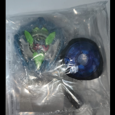 Packaged blue and green toy top with accessories in a clear plastic bag
