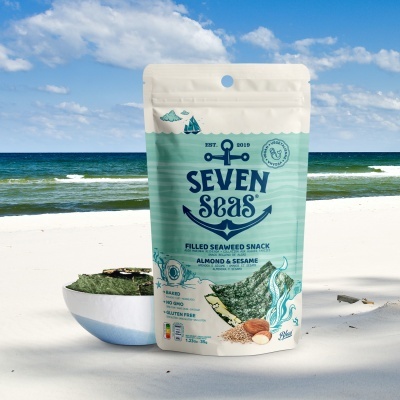Pacote de snack de algas SEVEN SEAS na praia com tigela e mar ao fundo