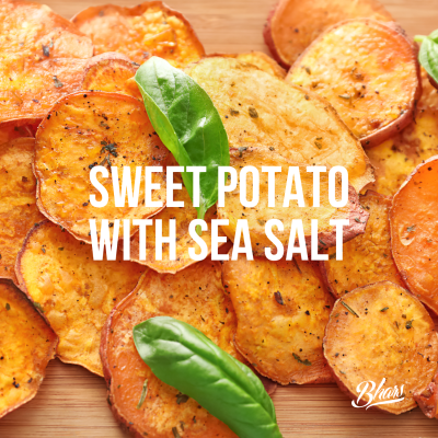 Batata-doce frita com sal marinho e folhas verdes sobre tábua de madeira