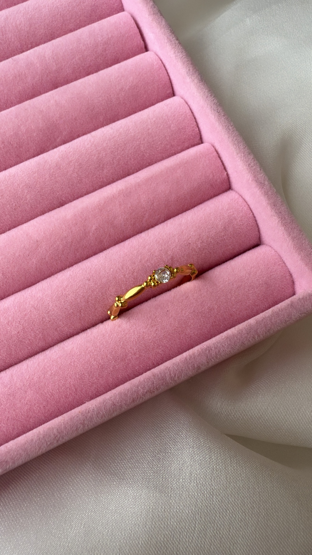 Anel dourado com pedra em caixa de veludo rosa