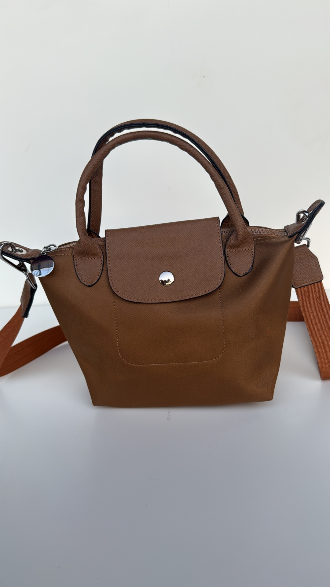 Mala castanha pequena tipo tote com alças e botão prateado