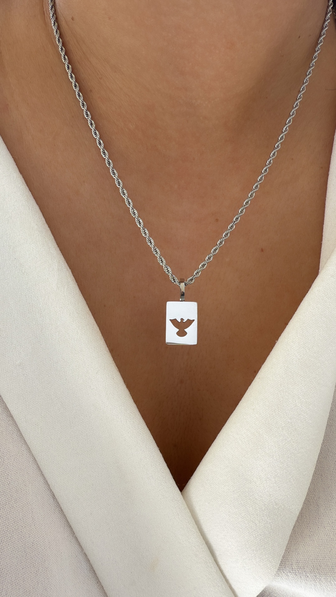 Colar prateado com pendente retangular e recorte de pá