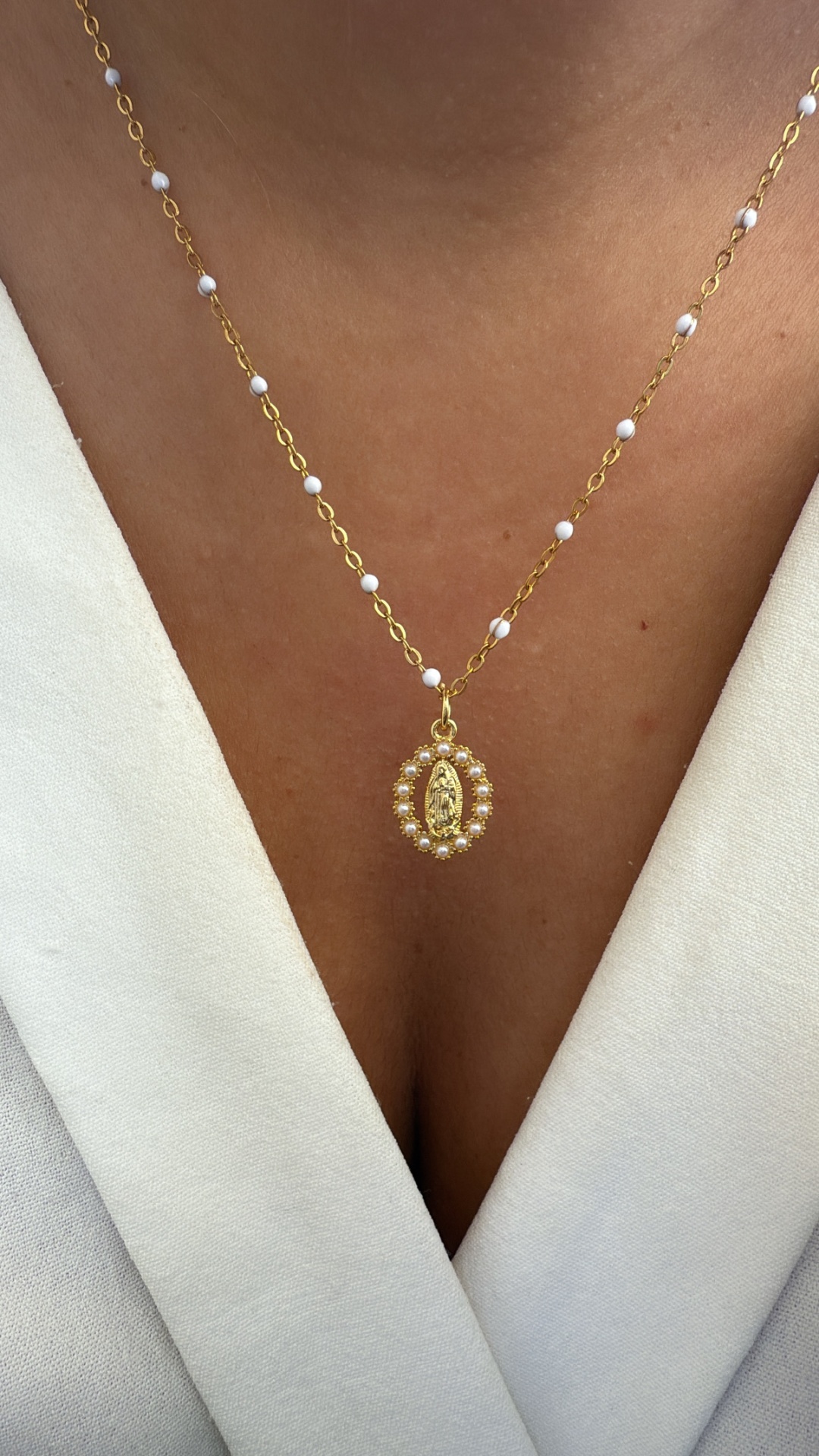 Colar dourado com pérolas pequenas e pendente oval