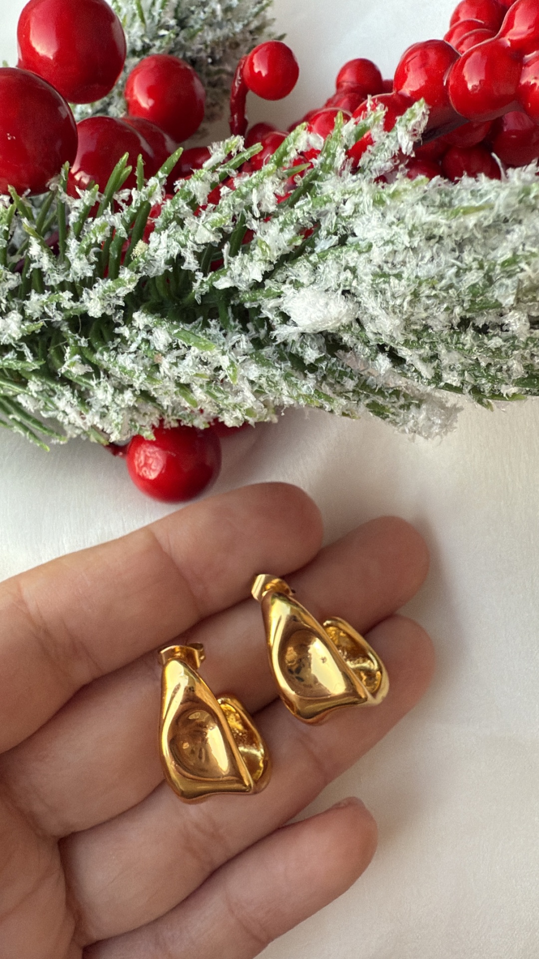 Brincos dourados abstratos com decoração natalícia no fundo