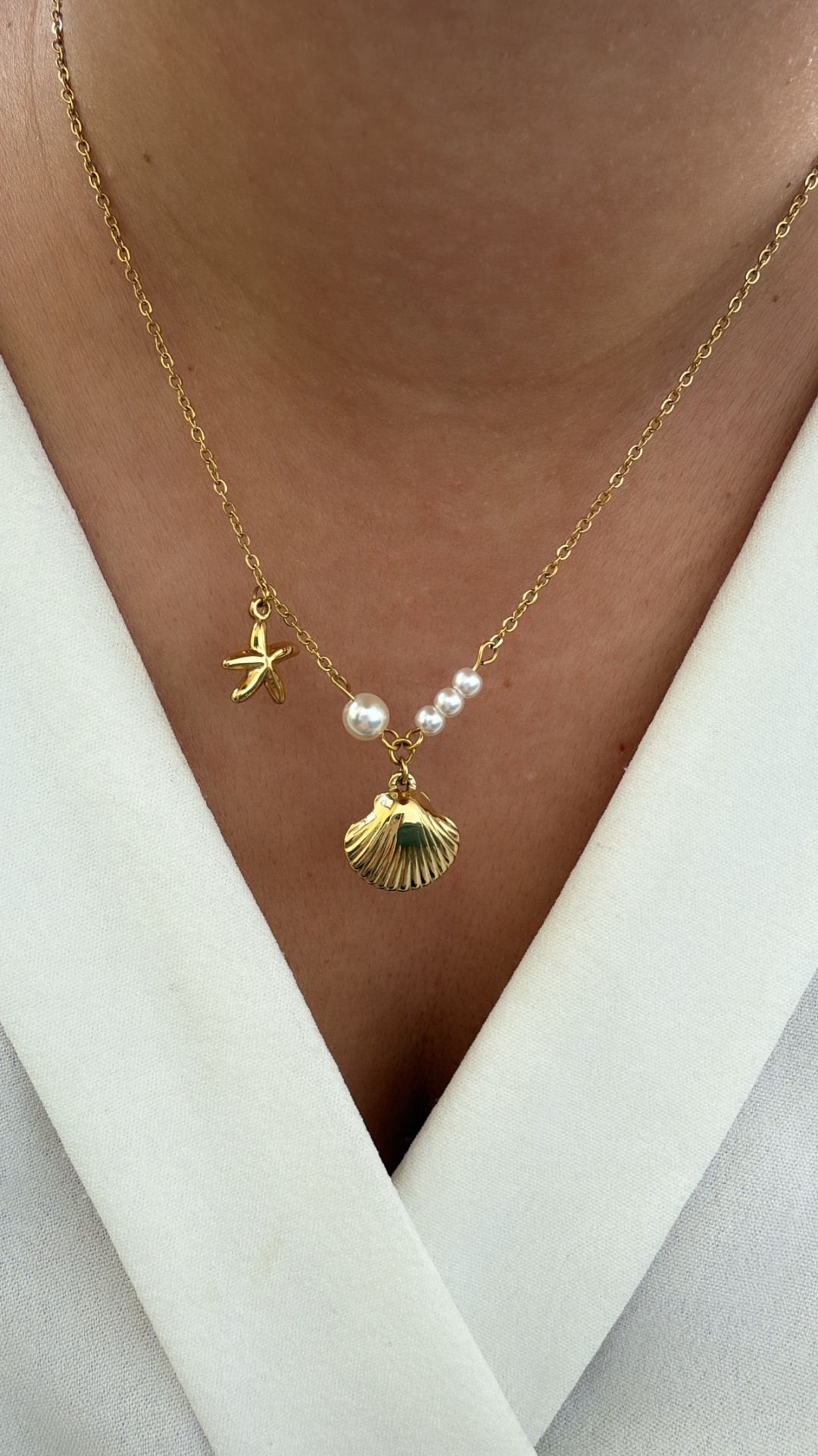 Colar com concha dourada, estrela do mar e pérolas em corrente fina dourada