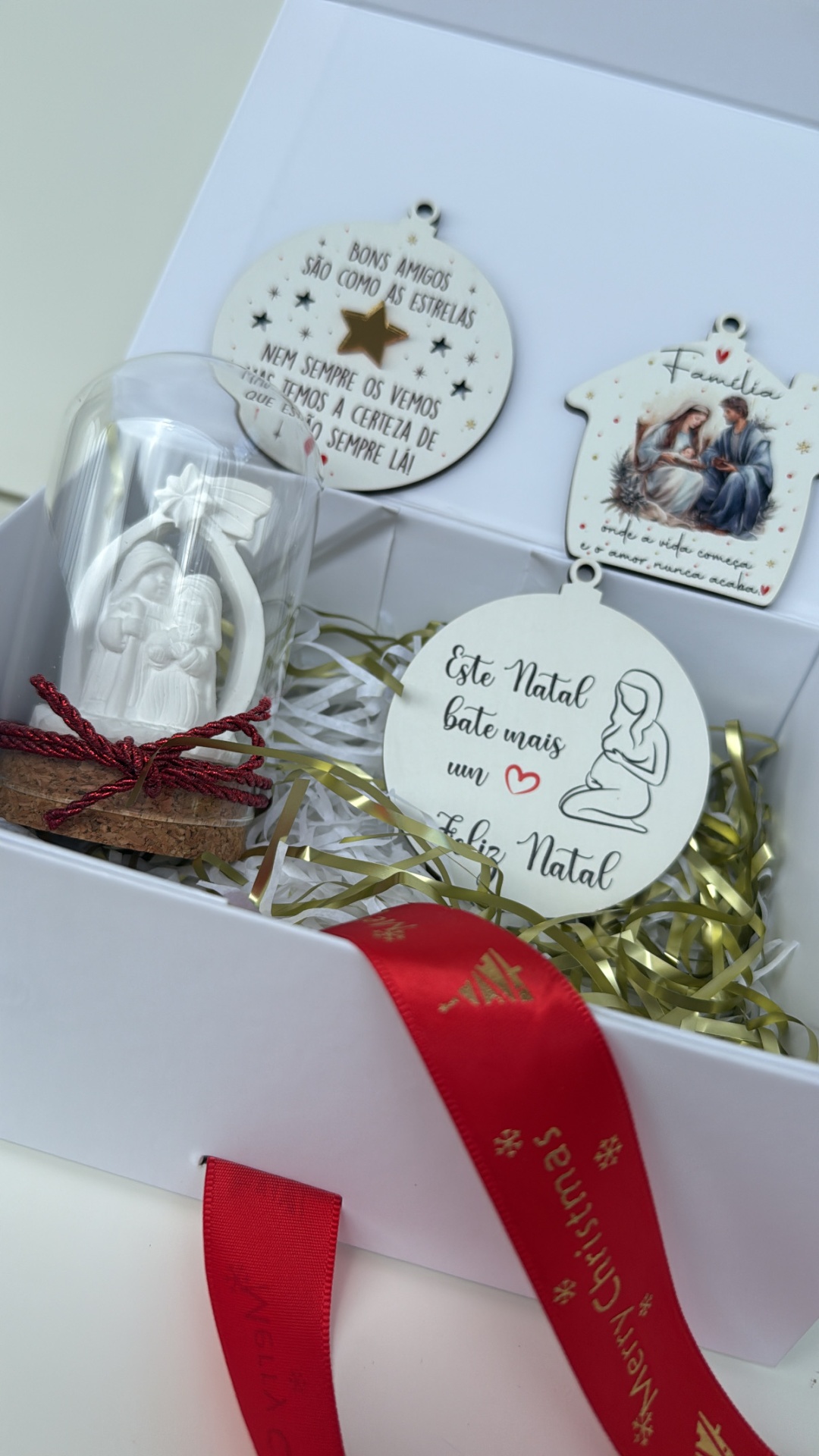 Ornamentos de Natal em caixa branca com fita vermelha e decoração de presépio em vidro