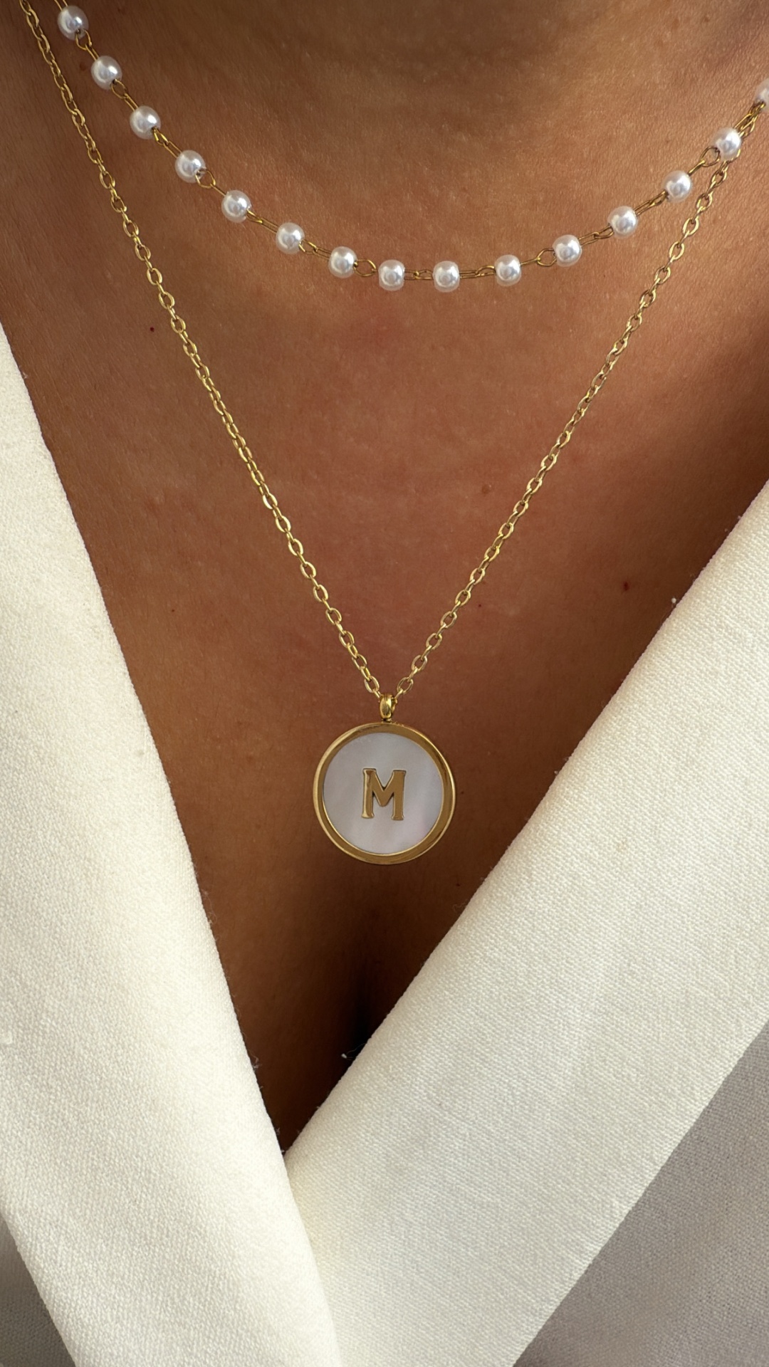 Colar duplo com pendente letra M e corrente de pérolas brancas