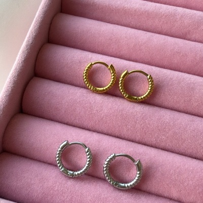 Quatro brincos de argola, dois dourados e dois prateados, em caixa de veludo rosa.