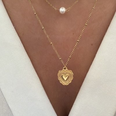 Colares dourados com pérola e pendente de coração no pescoço