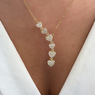 Colar dourado com sete corações brilhantes em pele com decote em V branco