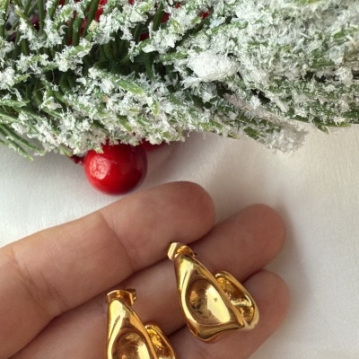 Brincos dourados abstratos com decoração natalícia no fundo