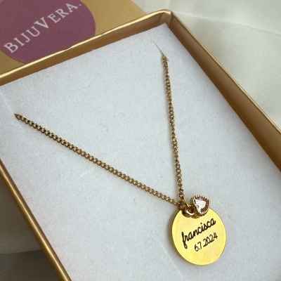 Colar dourado com pendente redondo gravado e pedra rosa em caixa dourada