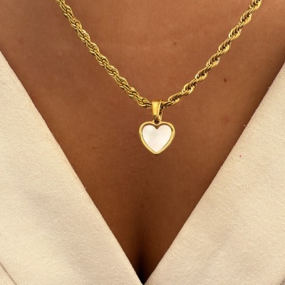 Colar dourado com coração branco ao pescoço