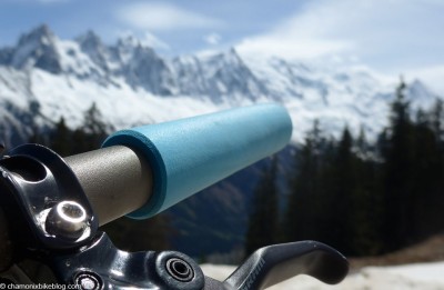Punho de bicicleta azul claro com montanhas nevadas ao fundo