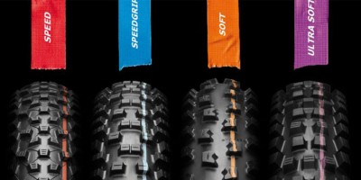 Quatro pneus de bicicleta com etiquetas coloridas e diferentes padrões de piso