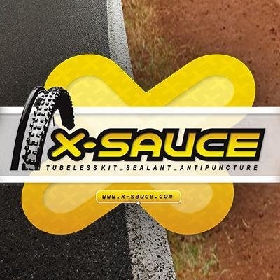 Rótulo de produto X-SAUCE para bicicleta com texto e ícone de pneu sobre fundo de asfalto e terra