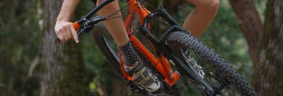 Bicicleta de montanha laranja e preta em floresta