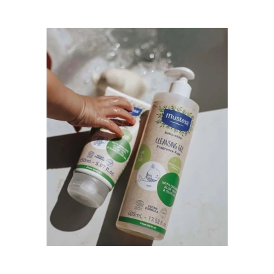 Dois frascos de produtos Mustela baby child com rótulos bege, azul e verde, um com doseador pump e tamanho 400 ml e outro de 150 ml.
