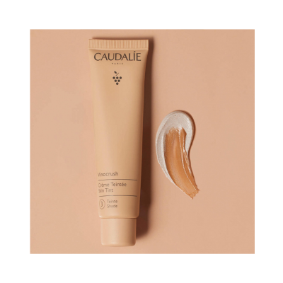 Tubo de creme tonificante Caudalie em tom claro com textura creme ao lado